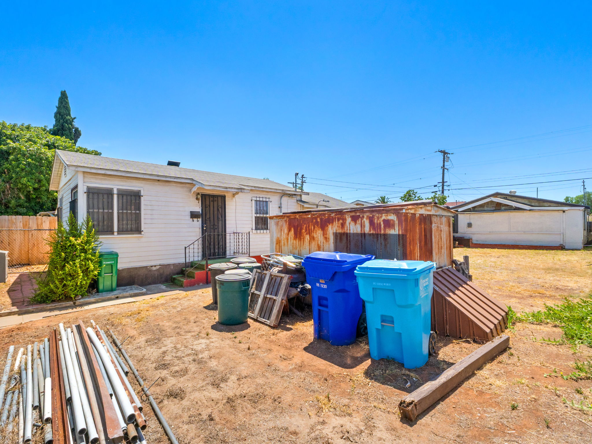 Existing property showing the front house, courtyard shed and loose items in the yard